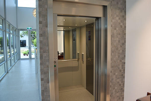 open doors of a lift with small detailed tile design