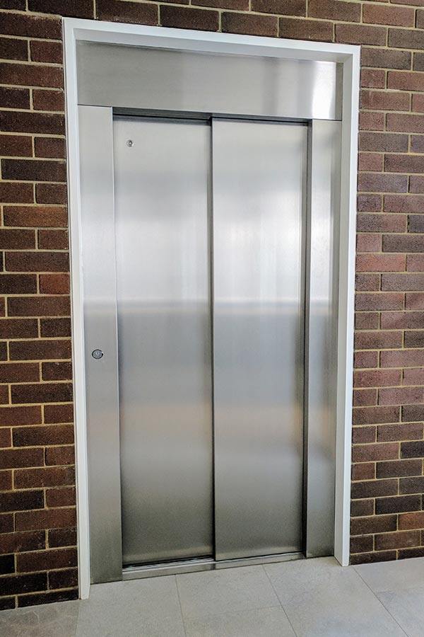 Closed doors of a lift surrounded by bricks in Cottesloe