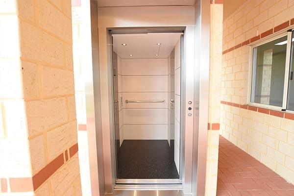 open doors of a lift with cream brick surrounds