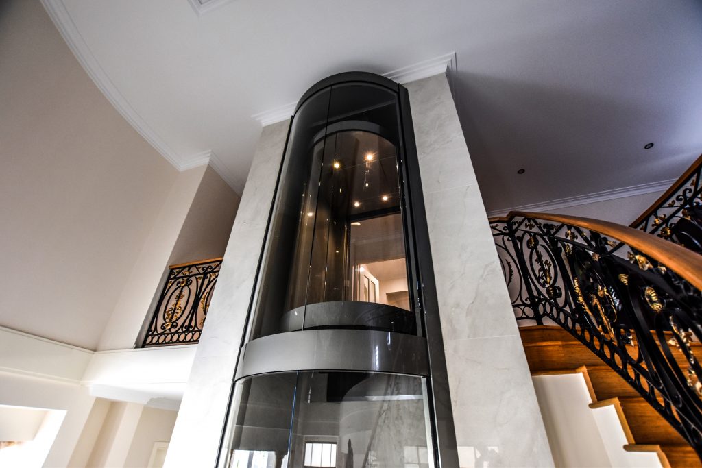Hydraulic elevator in a glazed metal shaft - how home lifts work - what you need to install a home lift - west coast elevators