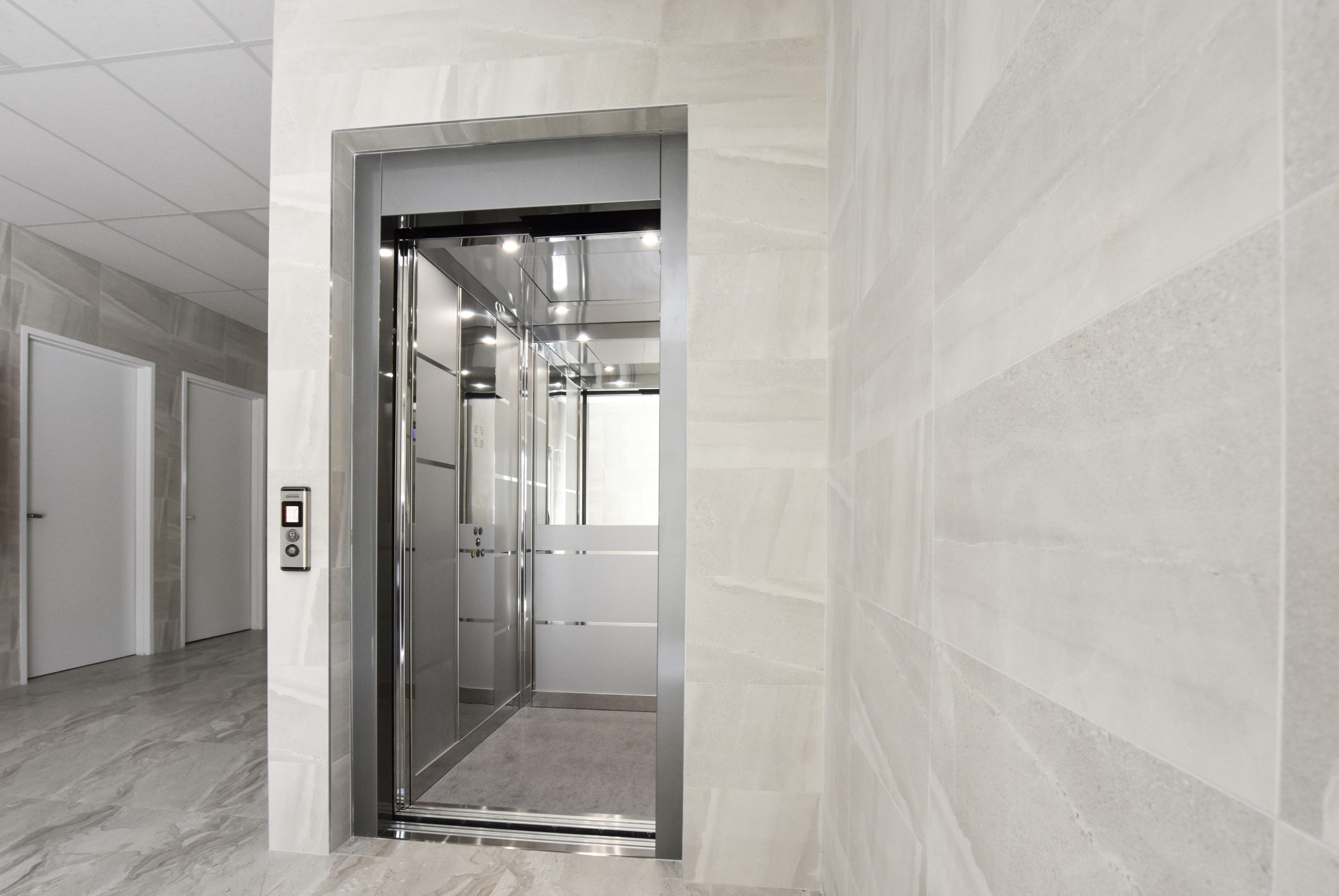 DDA lift in perth by west coast elevators dda compliant lift open in a commercial building lobby.