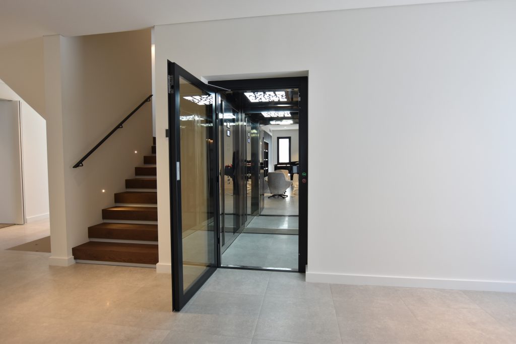 an open door home elevator next to a staircase.