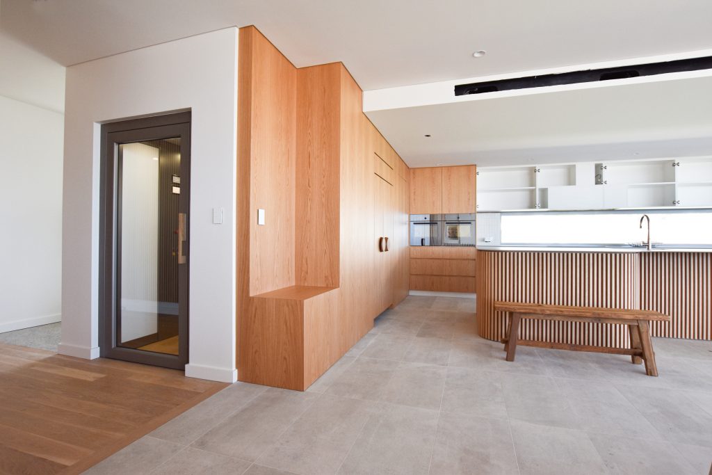 a closed door elevator in a living room and kitchen area.