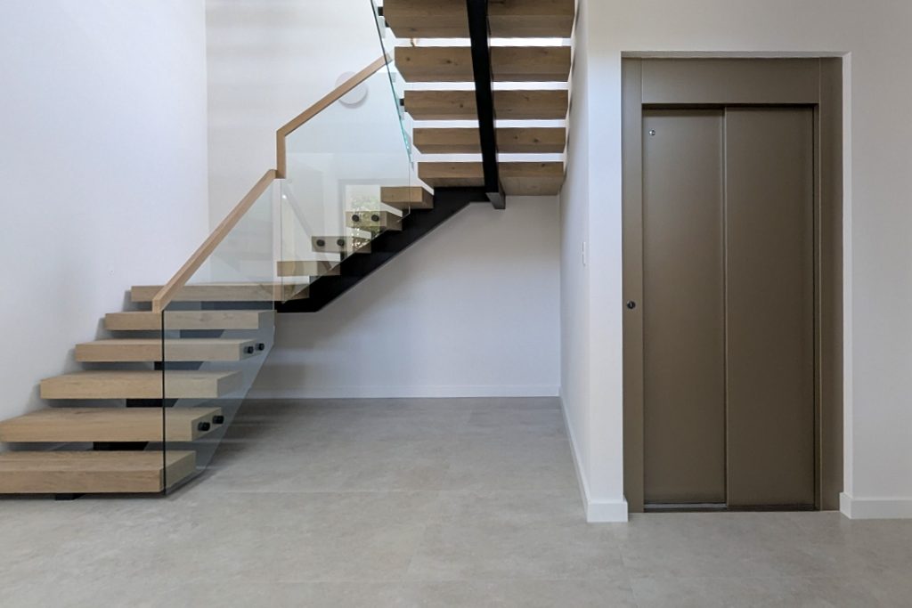 Modern staircase and lift in minimalist interior.