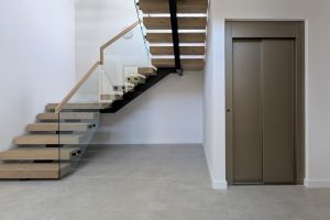 Modern staircase and lift in minimalist interior.