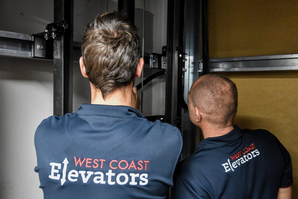 Technicians inspecting elevator machinery.