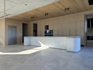 Modern kitchen with wooden cabinets and marble island.