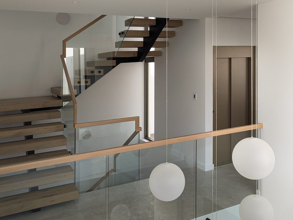 Modern interior with floating staircase and pendant lights.