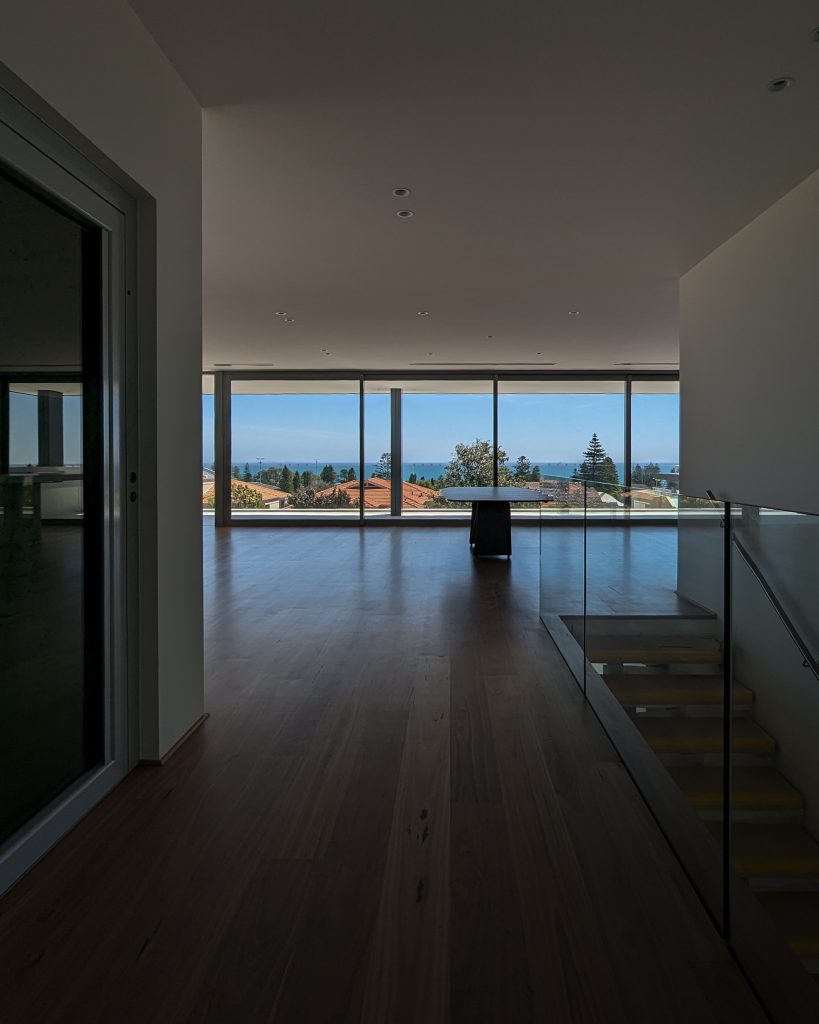 Modern room with ocean view through large windows.