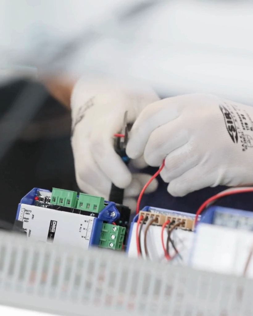 Technician wiring electrical panel with gloves