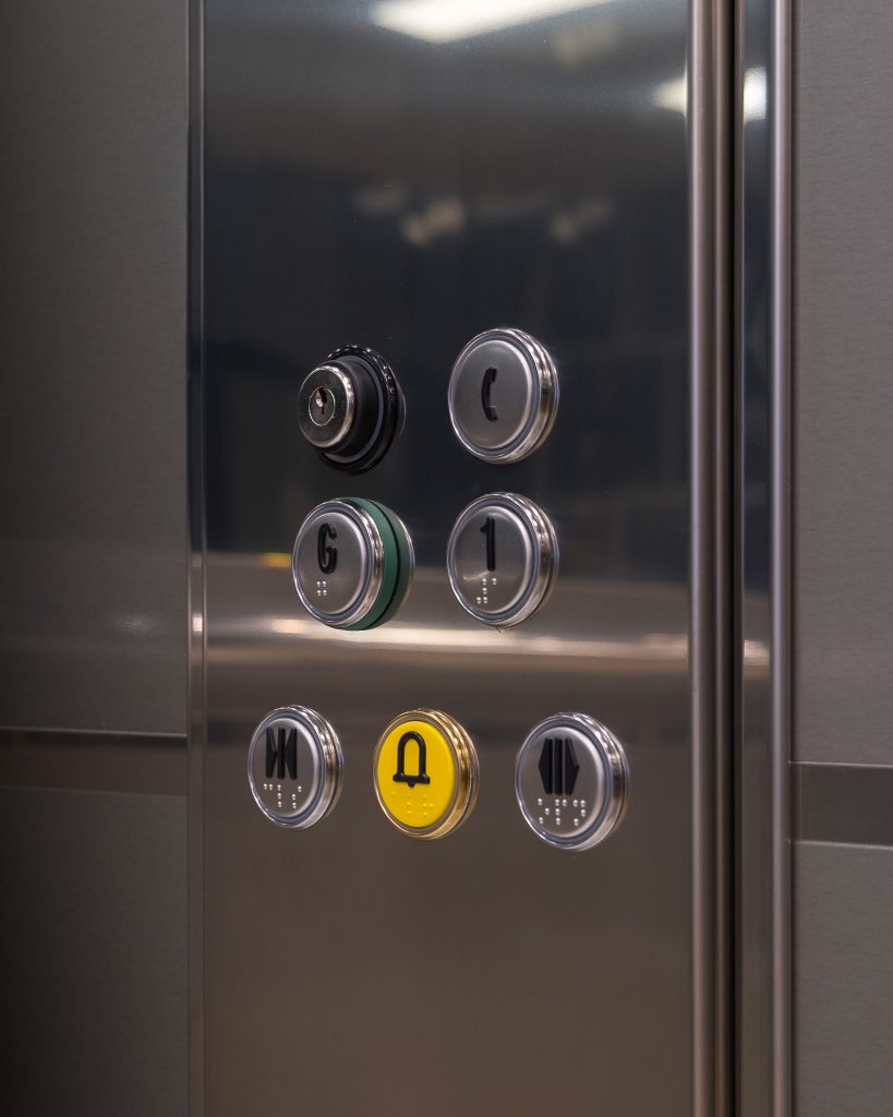 Close-up of elevator buttons with braille.