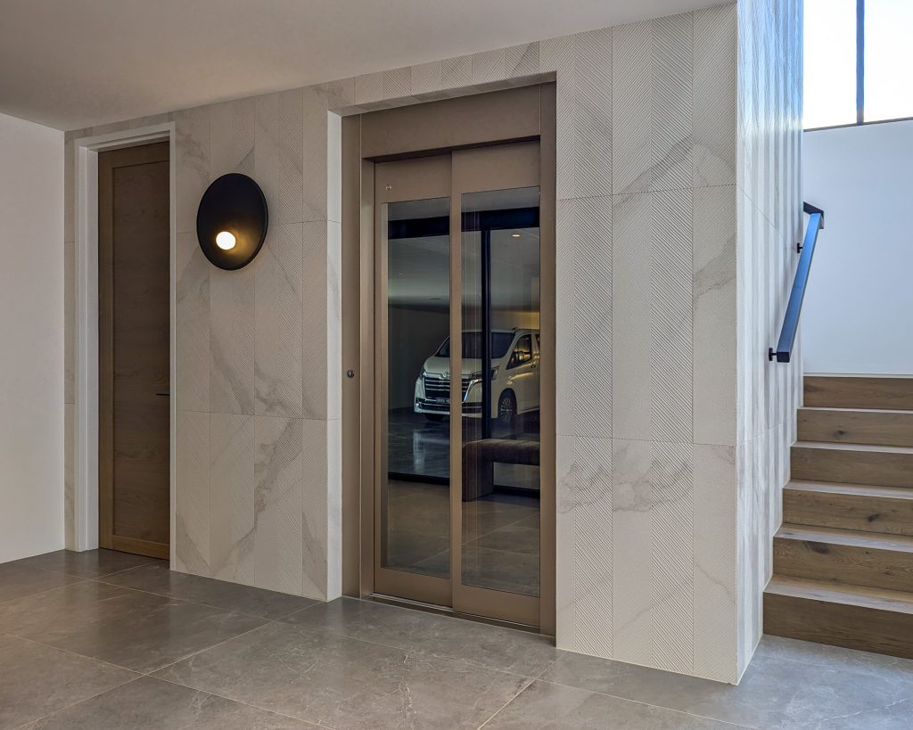 Modern home entrance with elevator and stairs.