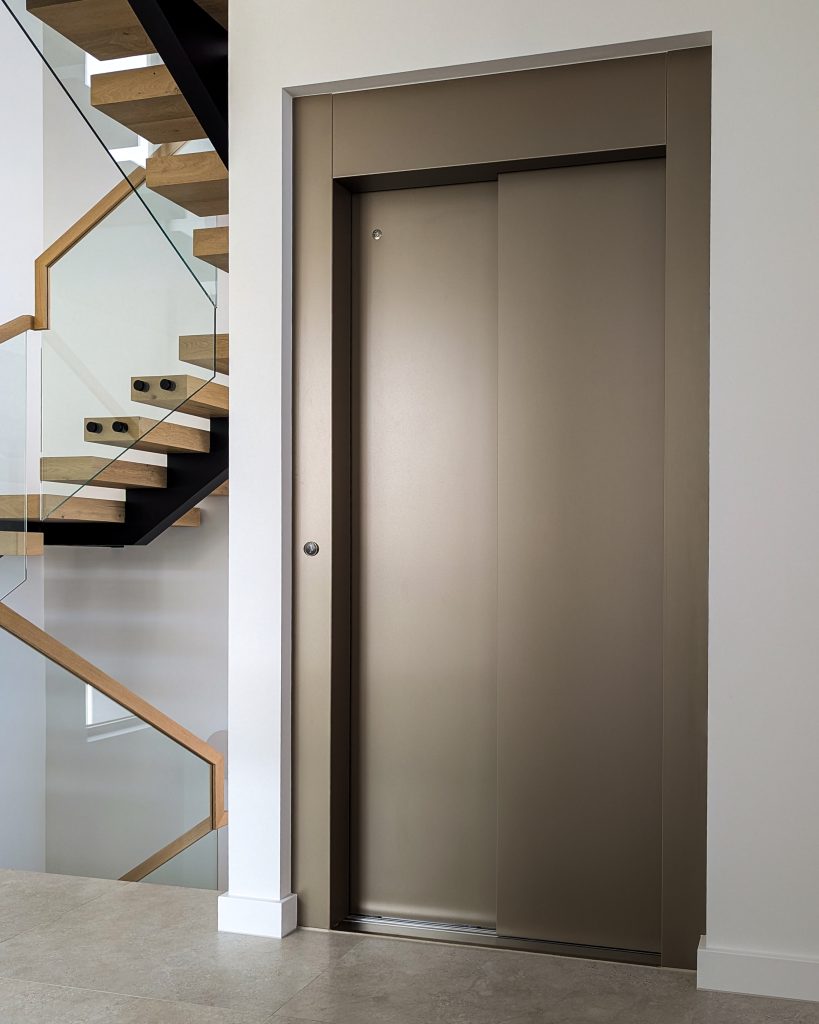 Modern interior with lift and wooden staircase.