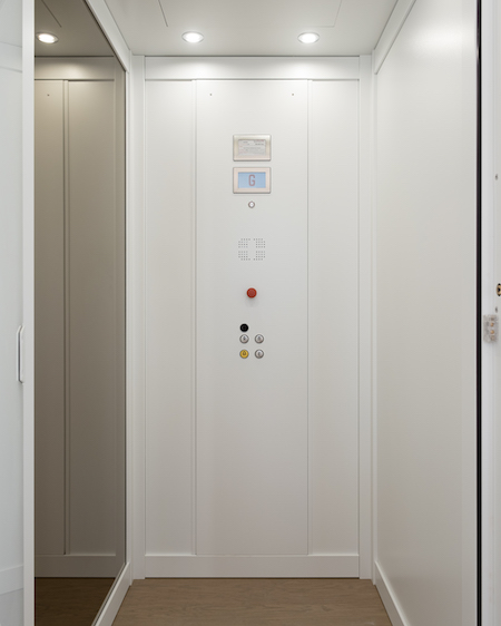 White modern lift interior with control panel.