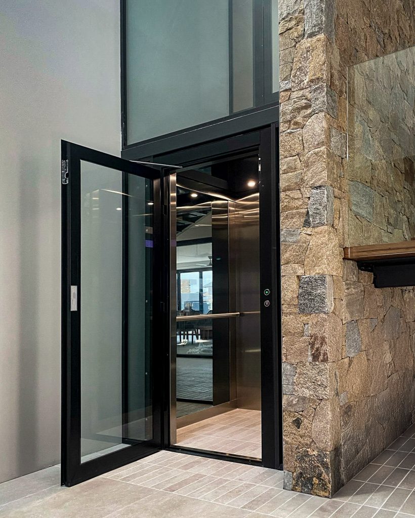 Modern home lift beside stone-clad entryway