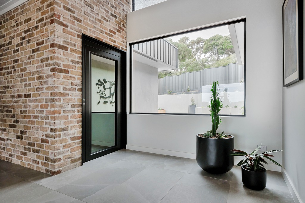 Modern residential lift with brick wall and potted plants