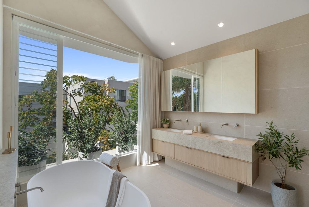 Modern bathroom with freestanding tub and large window