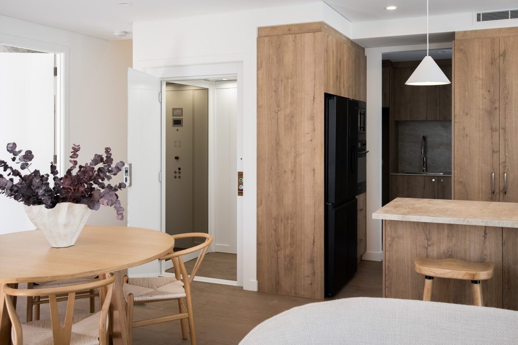 Modern apartment kitchen with timber cabinetry and lift