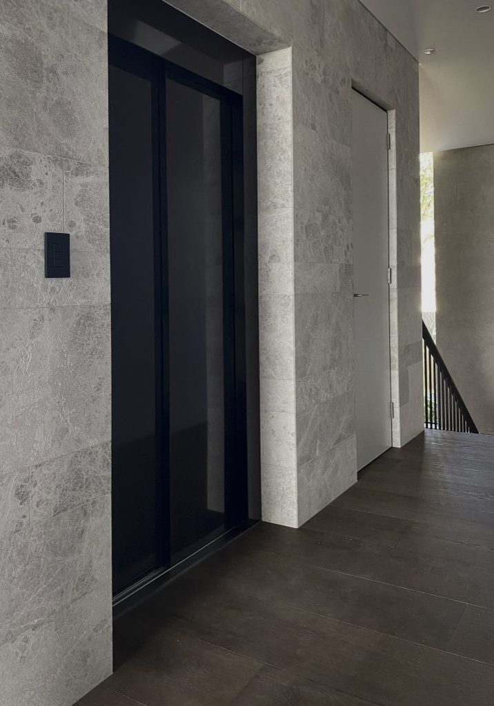 Modern stone hallway with black elevator doors