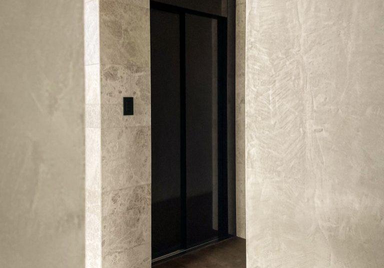 Modern elevator with marble walls and timber flooring