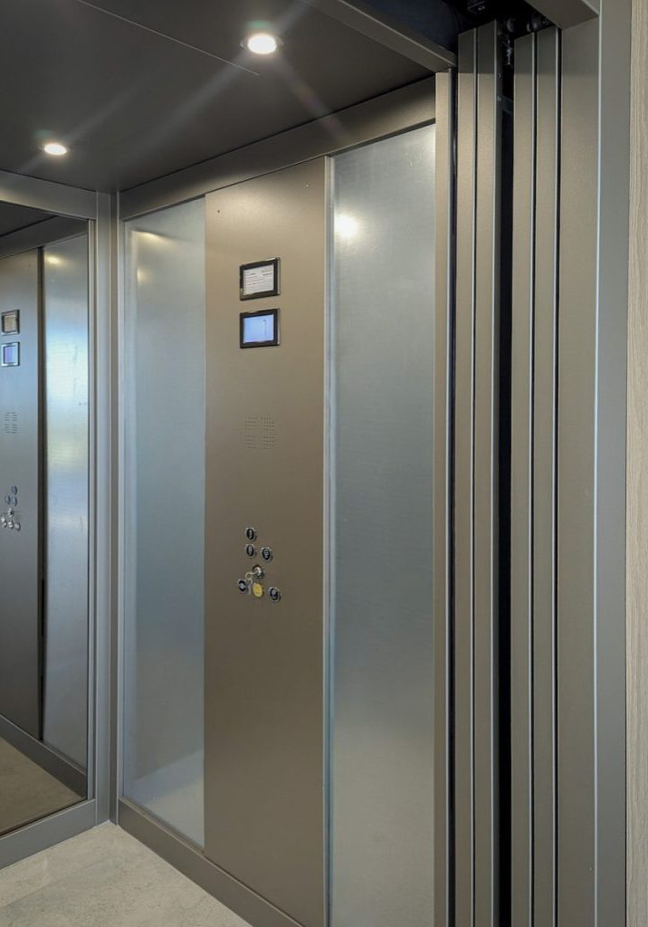 Modern residential lift with mirrored wall and controls