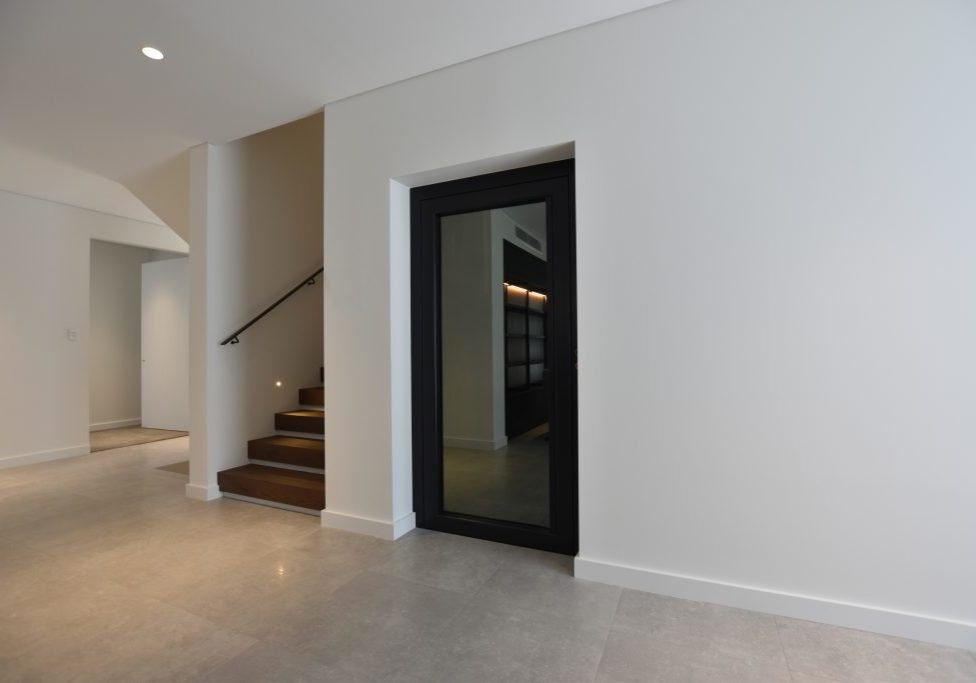 a closed door lift next to a staircase.