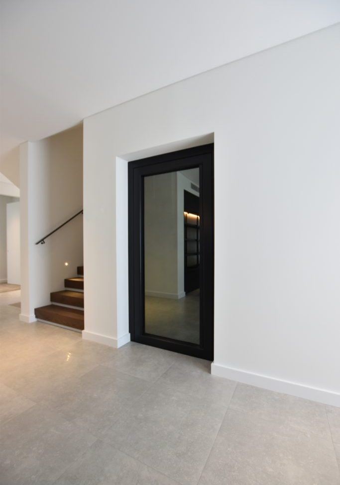 a closed door home elevator next to a staircase.