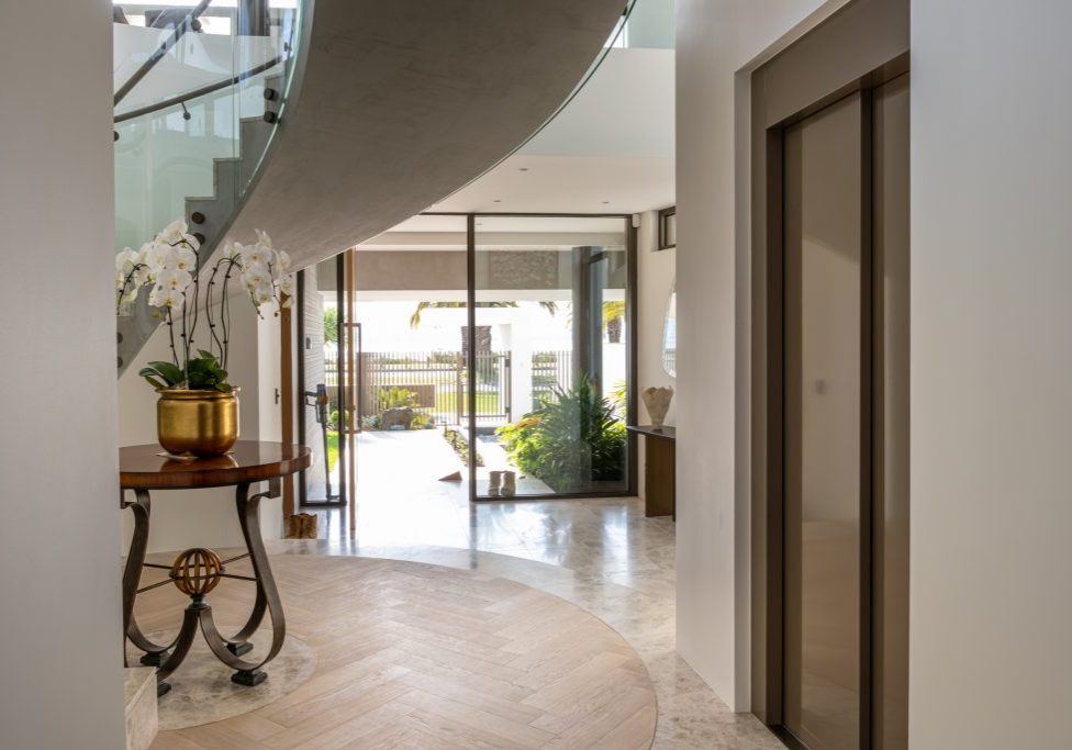 Modern foyer with curved staircase and glass doors