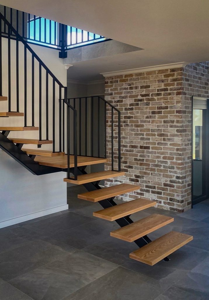Modern floating staircase with brick feature wall