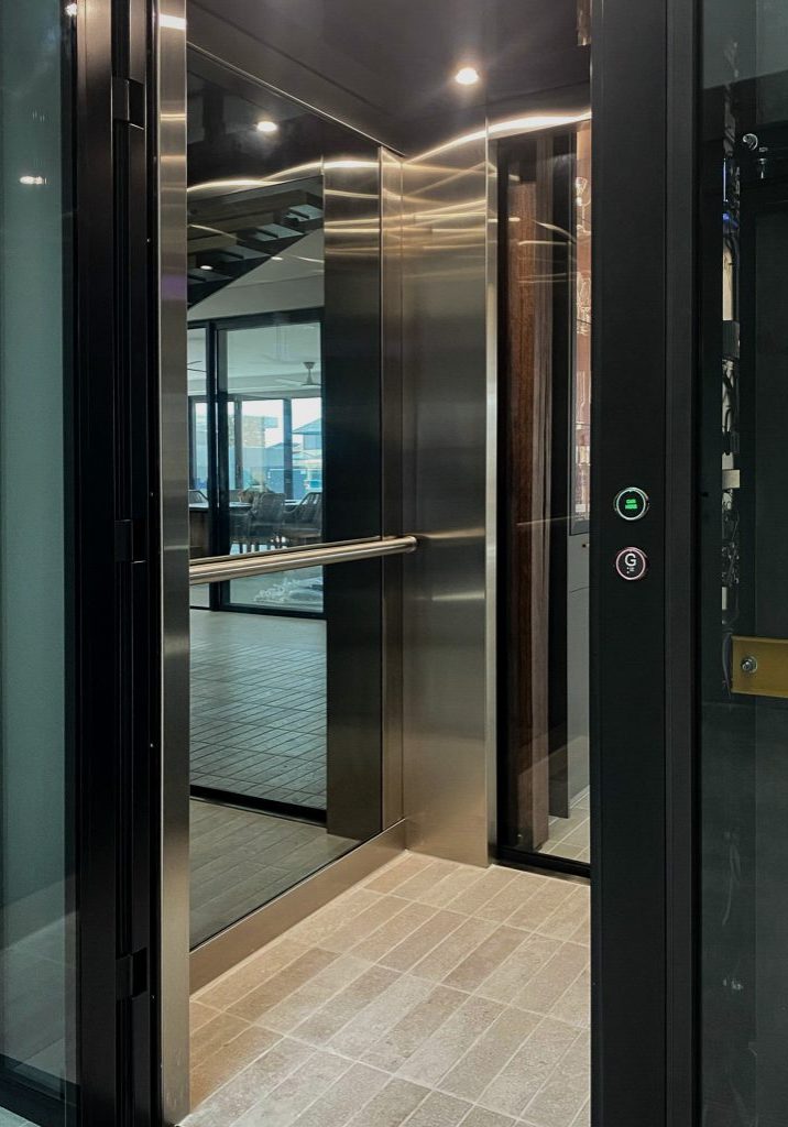 Modern glass residential lift with stainless steel interior