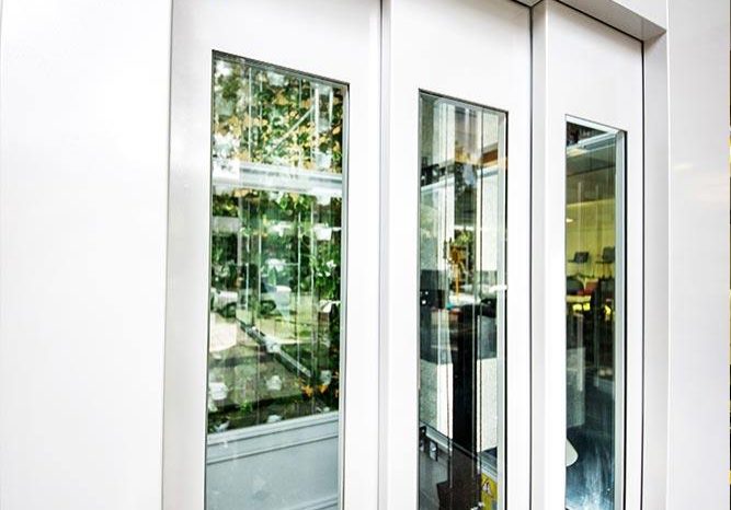 Glass doors of a White DDA Compliant commercial lift with glass features
