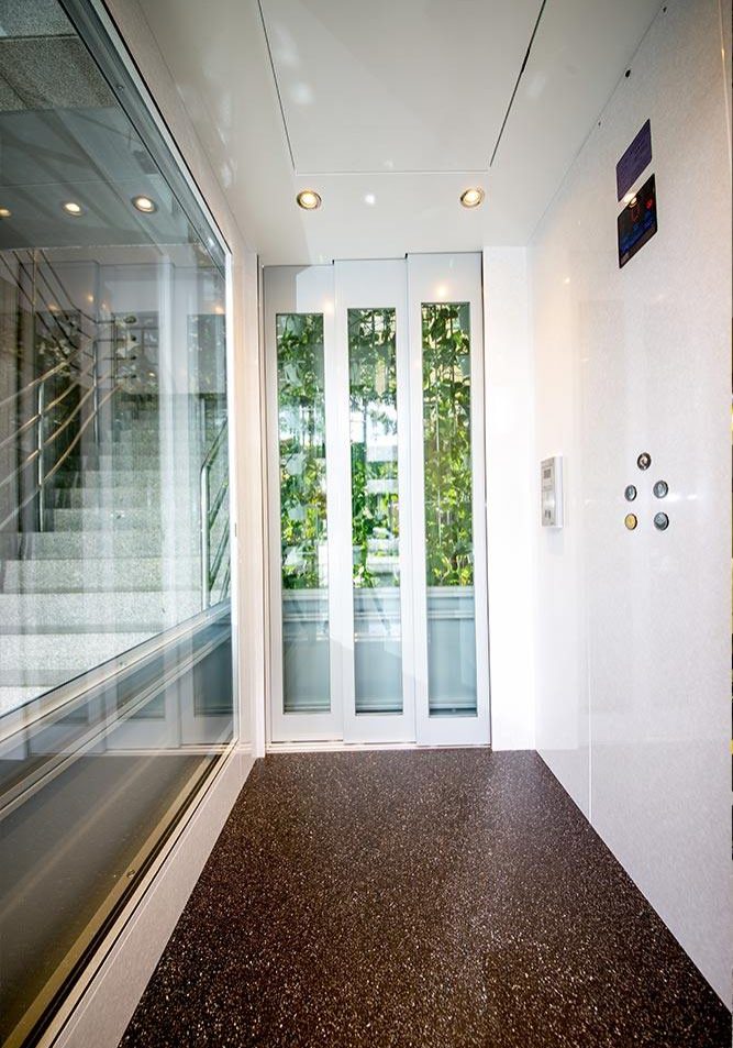 Glass doors of a White DDA Compliant commercial lift with glass features