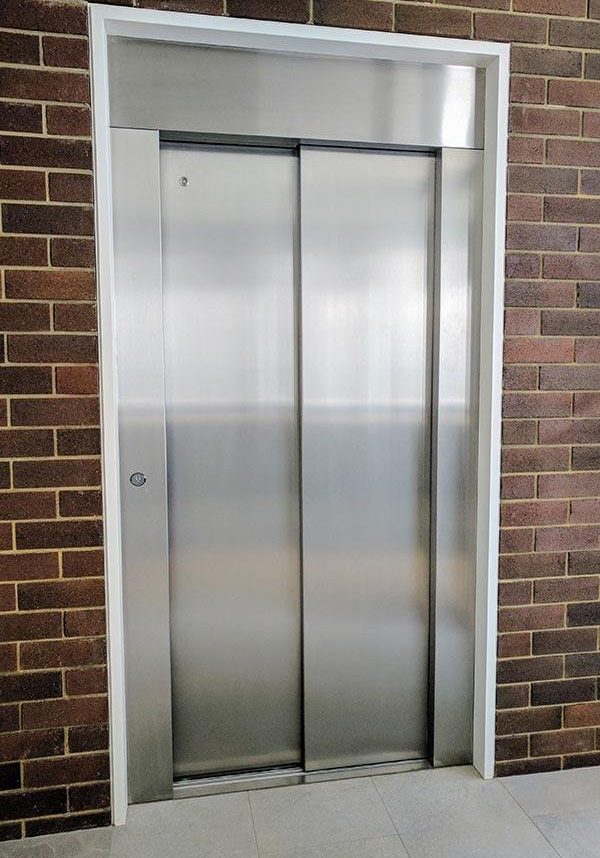 Closed doors of a lift surrounded by bricks in Cottesloe