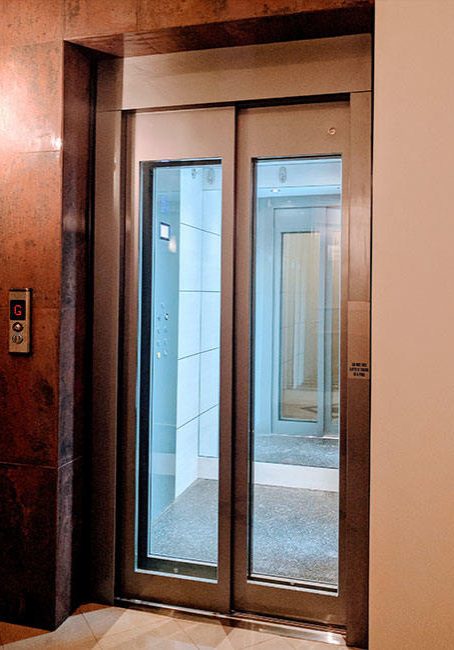 Closed glass doors of a DDA compliant commercial lift