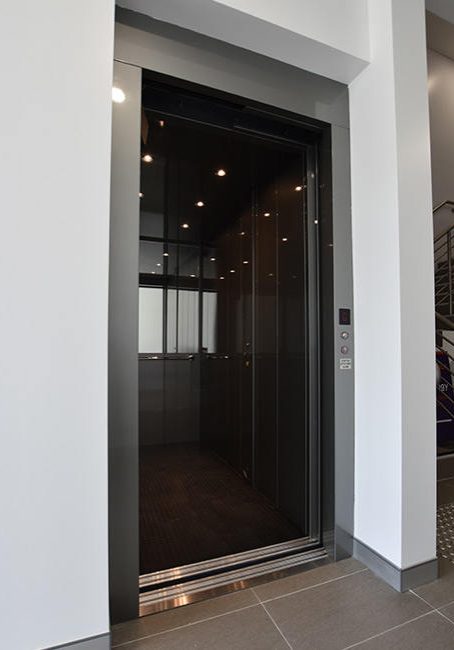 Open doors and black interior of a DDA compliant commercial lift