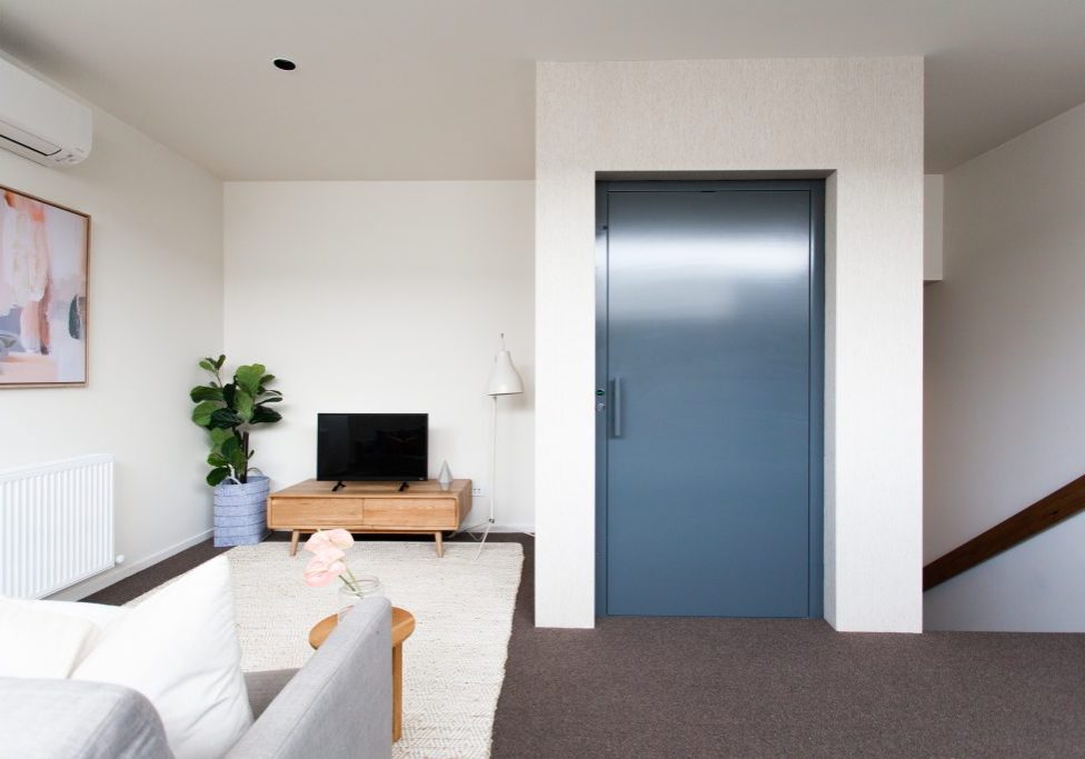 Home lift in living room with blue door