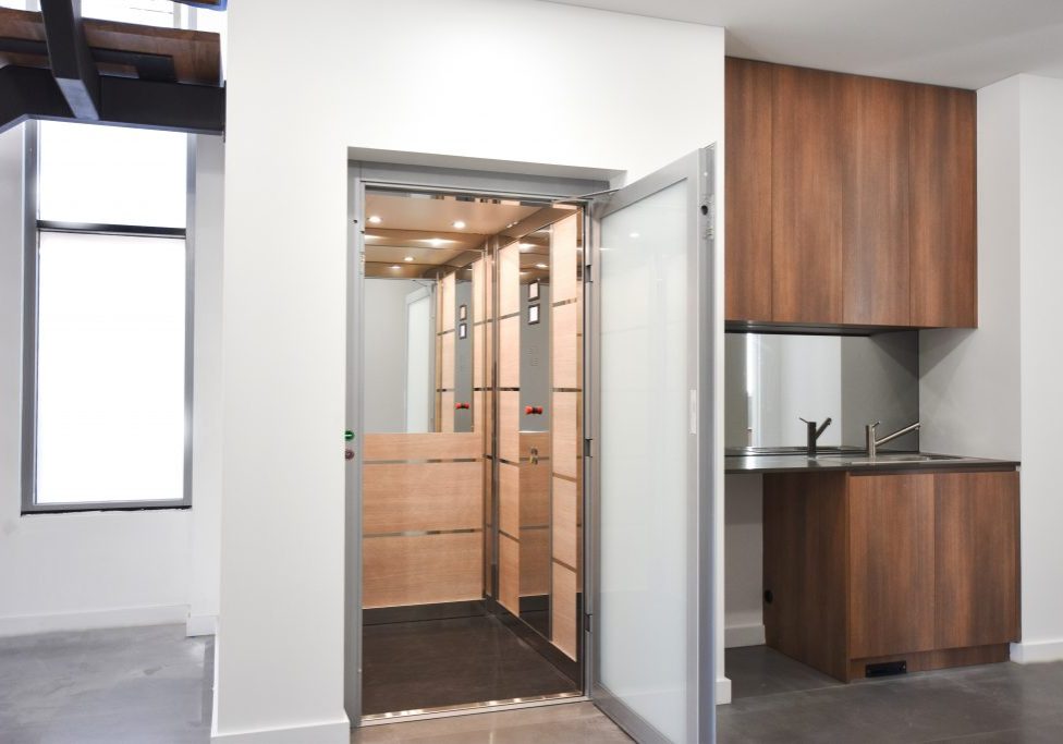 a lift in a new building with light coloured cabin