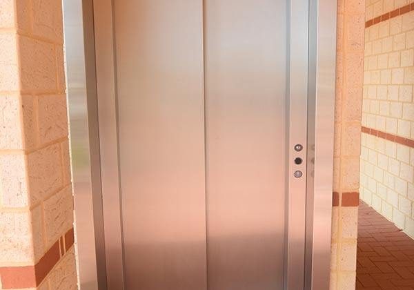 Commercial lift with closed doors and brick surrounds
