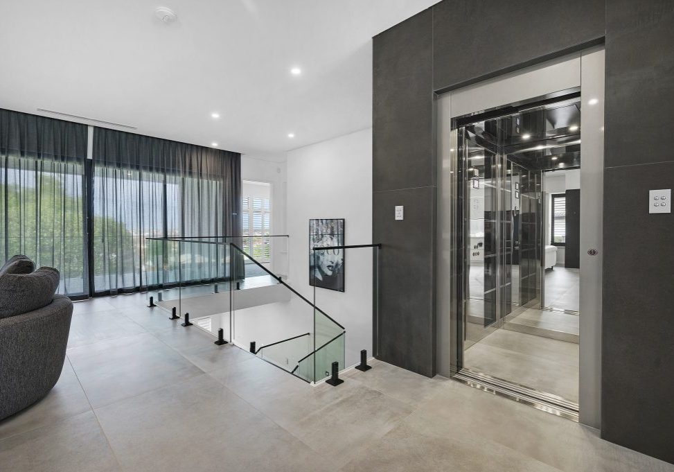 a dark charcoal elevator with open doors nestled in a luxury living space