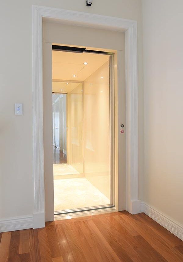 Open doors of a residential lift with white finishes. Installed by West Coast Elevators
