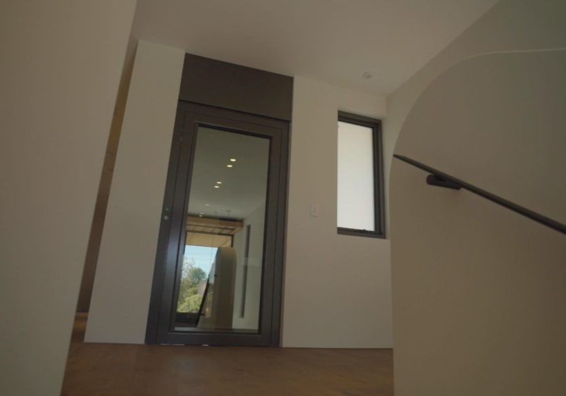 lift exterior in hallway, with a closed clear door.