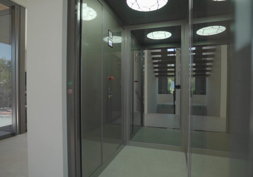 luxury lift with open doors and mirrored back wall.