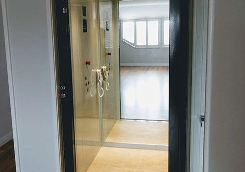 Open door of a South Perth residential lift with glass door and black finishing. Supplied and installed by West Coast Elevators