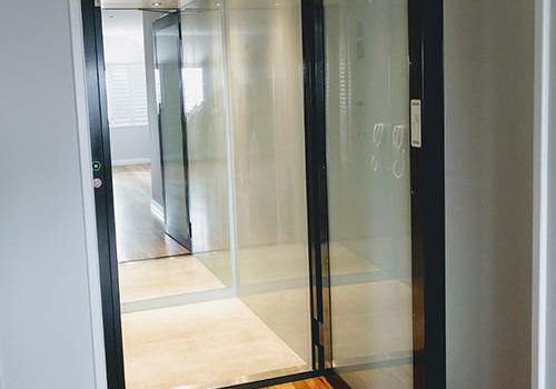 Open door of a South Perth residential lift with glass door and black finishing. Supplied and installed by West Coast Elevators