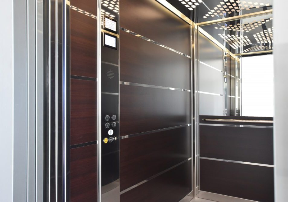 large lift cabin with dark wood panels, mirrored details and designer lights